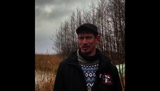Metsästäjä kerää kuolleita linttuja rannalta